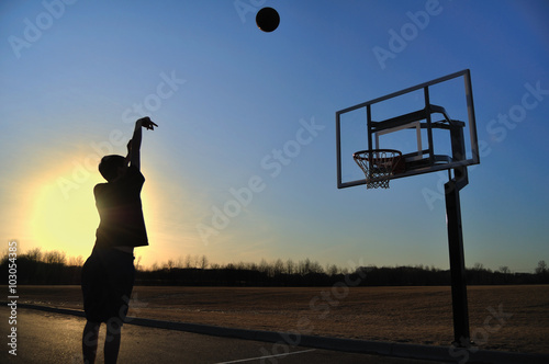 Fotomural Silueta de un muchacho adolescente que tira un baloncesto