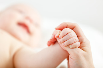 concept of parental love. baby hand holding finger of mother