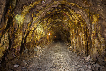 Old abandoned gold mine tunnel passage with yellow sulfur dirt