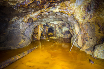 Old abandoned gold mine tunnel passage with yellow sulfur dirt