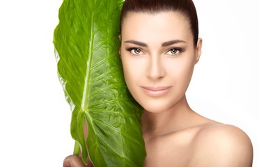Wall Mural - beauty spa girl near green leaf over white background