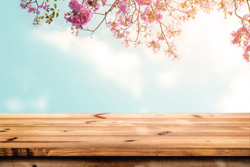 Wall Mural - top of wood table with pink cherry blossom flower on sky background - empty ready for your product d