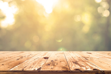 Wall Mural - top of wood table with blurred bokeh nature background - empty ready for your product display or mon