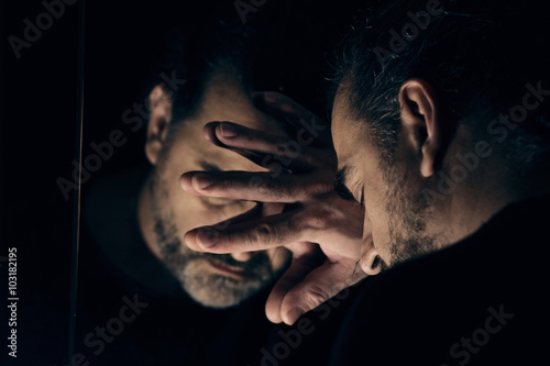 Fotografía Hombre en la desesperación, triste y solitario con la cabeza apoyada en una mano