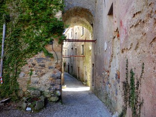 Arched doorway in abandoned Italian village of Balestrino - landscape color photo