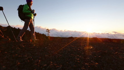 Wall Mural - Hiking couple - hikers trekking at sunset. Hiker man and woman in beautiful mountain nature landscape. Woman and man hikers walking during hike on volcano Teide, Tenerife, Canary Islands, Spain.