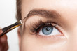 Closeup of a woman making a shape eyebrows with tweezers