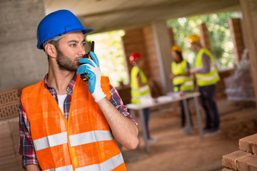 Wall Mural - Man speaking on walky talky at site