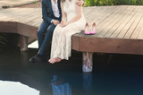 Fototapeta Londyn - Pretty strong young loving couple sitting on the bridge over the river, next to a bouquet of peonies, lifestyle, concept, love, tenderness