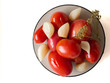 консервированные помидоры, чеснок и укроп на тарелке.