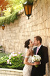 © IVASHstudio - Handsome romantic groom kissing beautiful brunette bride near ol