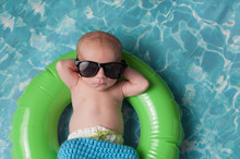 Newborn Baby Boy Floating On An Inflatable Swim Ring
