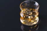 Fototapeta Kosmos - whiskey on the rocks on glass table