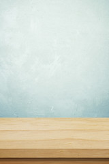 Empty wooden table over grunge cement wall background