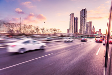 Wall Mural - Car driving on freeway at sunset, motion blur