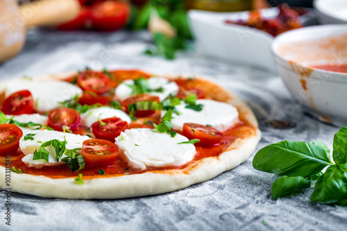 Fotografía Prepering pizza margherita con mozzarella para la cocción