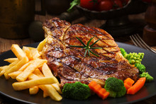 Grilled Beef Steak Served With French Fries And Vegetables On A