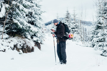 Wall Mural - hiker with cellphone in snowy mountains
