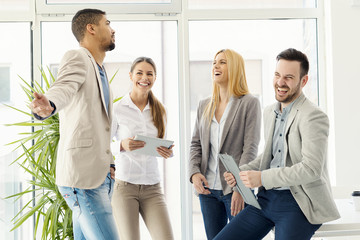 Wall Mural - Group of smiling business people standing and communicating