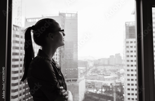 Fotografía Thoughtful woman looking out her city window.