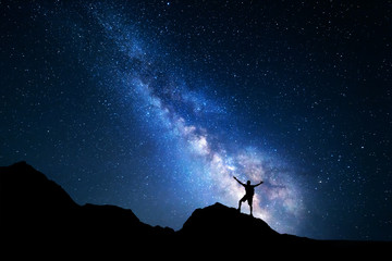 Wall Mural - milky way. night sky and silhouette of a standing man