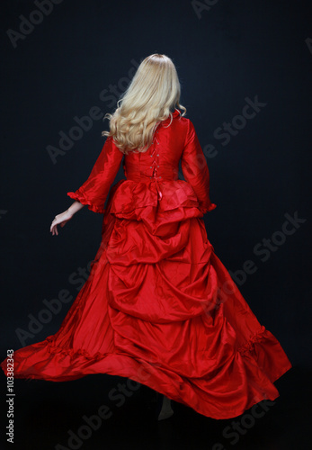 full length portrait of a beautiful blonde woman wearing a historical red silk, victorian era ball gown Canvas