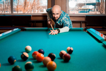 Nice young guy plays pool billiards