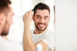 © Syda Productions - happy man brushing hair  with comb at bathroom