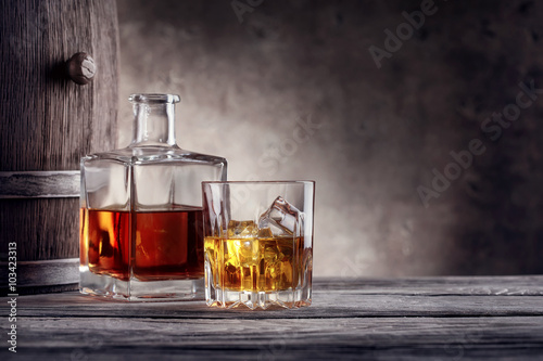 Fotografía Decantador cuadrado y un vaso de whisky con hielo