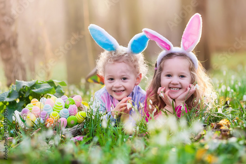 Photo Kids on Easter egg hunt in blooming spring garden