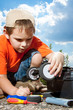 © tcsaba - Little boy repaire the radio control car outdoor near field