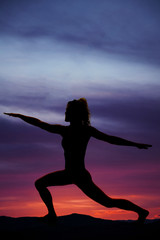 Wall Mural - silhouette of a woman in lunge with arms out in sunset