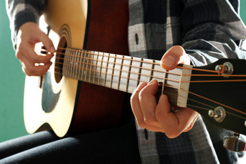 Canvas Print - Musician plays guitar on blue background, close up