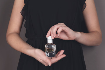 Young woman holding bottle perfume