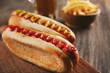 Canvas Print - Hot dogs with fried potatoes on cutting board