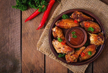 Wall Mural - Sour-sweet baked chicken wings and sauce.Top view