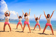 © SlavaStock - cheerleaders dance on beach with hands upwards against azure sea