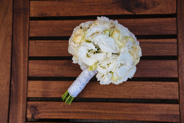 Wedding bouquet of yellow and white roses  lying on wooden backg