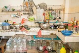 Fototapeta Paryż - untidy Kitchenware ; Pile of dirty dishes in sink and counter in the kitchen