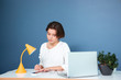 © Drobot Dean - Pensive cute woman sitting and using mobile phone on workplace