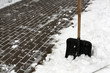 Black plastic snow shovel and pavement.