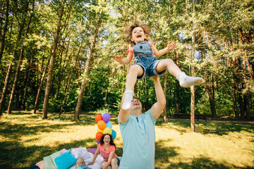 Wall Mural - Young family with kids having fun outdoors.