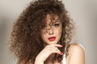 © vladimirfloyd - beautiful girl with long curly hair on a gray background