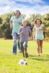  couple with teenager  playing with soccer ball