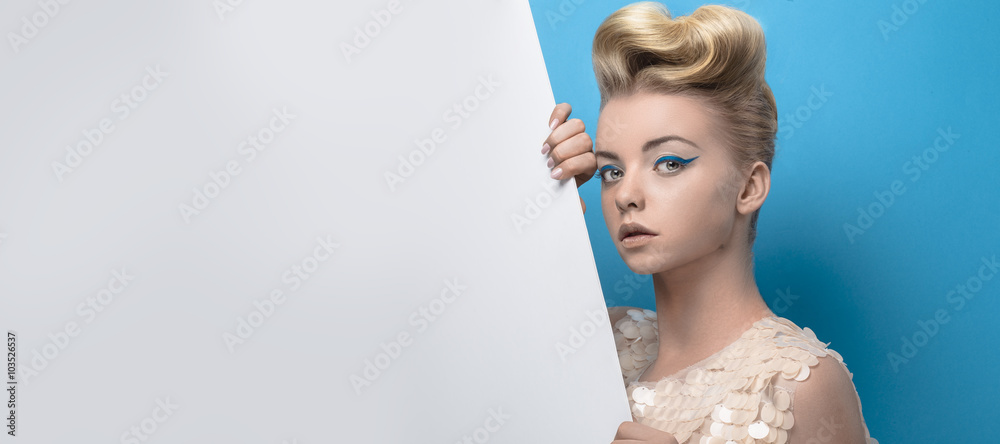 Beautiful young blonde woman holding a white board - obrazy, fototapety, plakaty 