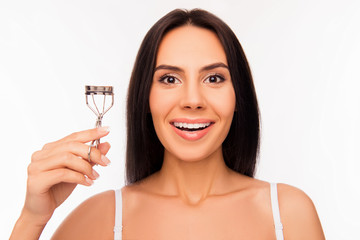 Poster - Close up portrait of smiling girl holding culer for eyelashes