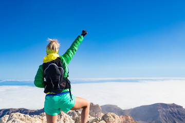 Wall Mural - Woman hiking success arms outstretched on mountain top