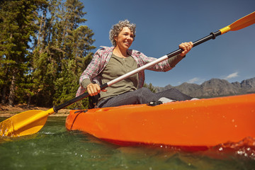 Wall Mural - Senior woman canoeing on summer day