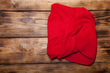 Red kitchen towel on old wooden burned table or board for backgr