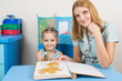 © madhourse - Five-year girl and mother looking at the herbarium of the leaves in the album and looked in the frame